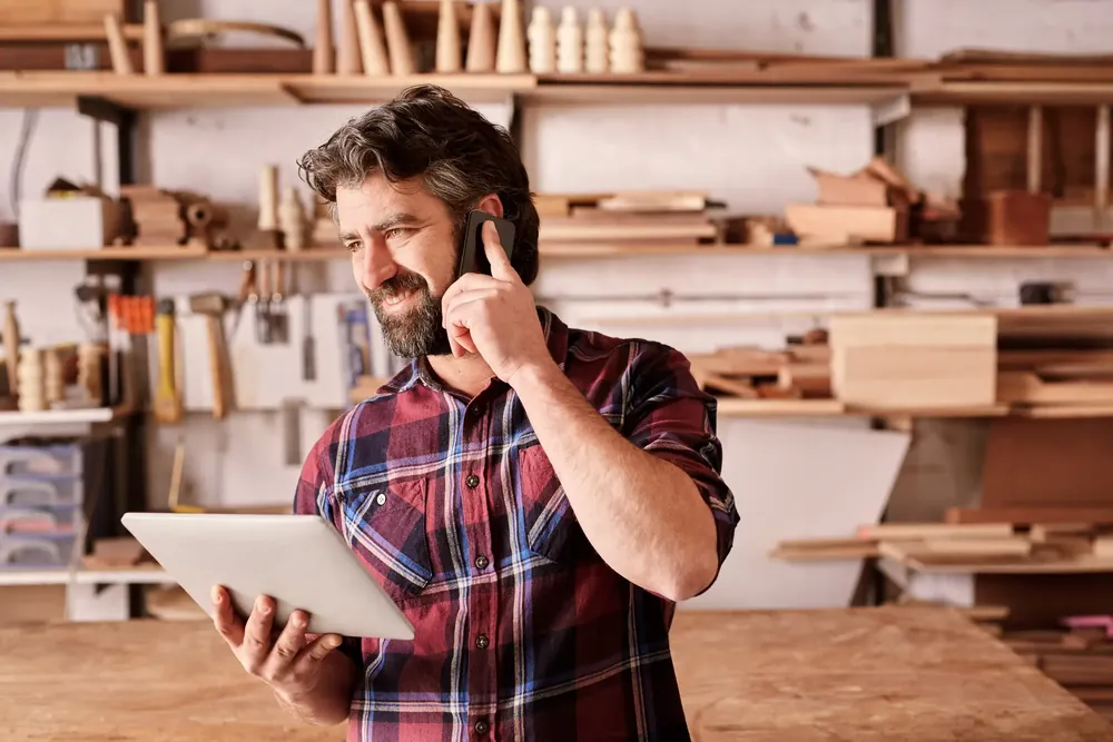 Man on the phone holding a tablet